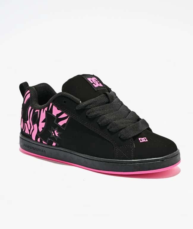 Zapatilla DC Court Graffik negra con estampado de cebra rosa en el talón, logos DC rosados y borde rosa en la suela